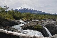 Wer ist der Schönste im ganzen Land?  Um diesen Titel streiten sich weniger die drei Vulkane Villarrica, Llaima und Osorno selbst, sondern meist die Besucher Chiles, die sich bei den fast perfekten Kegelformen dieser drei nicht für einen entscheiden mögen. Wie auch immer, der 2650 m hohe Volcán Osorno, wie er hier von den Saltos del Petrohué zu sehen ist, ist auf jeden Fall ein heißer Kandidat für den Titel.  Der 1926 gegründete Nationalpark Vicente Pérez Rosales ist das älteste Schutzgebiet in Chile und hat gemeinsam mit mehreren anderen, teils grenzüberschreitenden Parks das Anliegen, die Fauna und Flora Nordpatagoniens zu schützen.