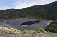 Schuhgröße 153 (m!)  Wie der Fußabdruck eines Riesen wirkt der See im kleineren der beiden Krater des Irazú. Während der grüne Säuresee des Hauptkraters 300 m unterhalb des großen Ascheplateaus liegt, geht es zur Sohle des Crater Diego de la Haya nur ca. 80 m herunter. Da der Irazú hoch aktiv ist und der letzte große Ausbruch noch 1994 stattfand, ist nicht sicher, wie lange das Erscheinungsbild der Krater in dieser Form erhalten bleibt. Schon der nächste Ausbruch kann ganz neue Ansichten hervorbringen und den derzeit leichten touristischen Zugang auf unabsehbare Zeit beeinträchtigen. Zwei Tage nach unserem Besuch im November 2008 verschüttete ein kleiner Bergrutsch die Zufahrtstraße so nachhaltig, dass die am Gipfel festsitzenden Besucher erst Stunden später wieder den Berg verlassen konnten.  2008