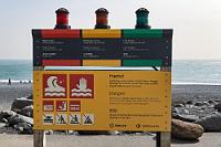 Brandungsampel  Ganz ungefährlich scheint es hier auch nicht zu sein, wie das dringend angeratene Studium der Hinweise auf dem ampelähnlichen Warnschild nahelegt. Die Gefahr, von der unberechenbaren Brandung ins offene Meer gezogen zu werden, besteht zwar nicht nur hier, ist aber wegen des großen Andrangs speziell an diesem Küstenabschnitt und tödlicher Ereignisse in der Vergangenheit sicher sinnvoll.  Während Maren sich um die Bezahlung der Parkgebühr am Automaten des Beach Restaurants kümmert, suche ich die Kameras zusammen und schalte dabei hoffnungsvoll noch einmal die schon fast abgeschriebene Videokamera ein: sie funktioniert!!! Testweise schalte ich verschiedene Modi durch – alles läuft, wie es sein soll! Sicherlich hat die sonnengewärmte Luft im Inneren unseres Auto im Laufe des Tages das letzte Bißchen Feuchtigkeit weggetrocknet.