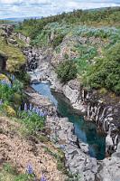 Clearwater Canyon  Mit dem Hvammsförður haben wir den letzten Fjord passiert und verlassen die 60 nun, um über die 54 auf die Snæfellsnes Halbinsel zu gelangen. Die Straße ist asphaltiert und es ist wenig los. Wir kreuzen eine Brücke, unter der wir im Vorbeifahren einen zerklüfteten Flusscanyon erspähen. Gleich hinter der Brücke links ist ein Parkplatz, auf den wir interessiert einbiegen.