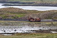 A hidden gem  Die 54 ist auf diesem Teilstück eine gut befestigte Schotterstrecke, der wir entlang der Küste durch eine abwechslungsreiche Landschaft folgen. Die Küstengewässer sind gesprenkelt mit unzähligen kleinen Inselchen, von denen eine mit einem unwiderstehlichen Motiv geschmückt ist, welches einen sofortigen Zwischenhalt erfordert. Und gerne machen wir uns die ironische Bezeichnung zu eigen, die laut Google ein 'local guide' diesem idyllischen Schiffswrack am Ufer des Inselchens Stykkisholmur verpasst hat. Nun ist es auch nicht mehr weit bis zu der Kreuzung, an der vom Snæfellsnesvegur der Heydalsvegur abzweigt, auf dem wir schon vor zwei Tagen die Südküste der Halbinsel erreicht haben.