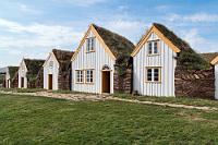 Kulturtour  Heute umrunden wir nicht noch einmal die Tröllaskagi Halbinsel, sondern fahren auf dem Hringvegur weiter nach Westen. In Varmahlíð verlassen wir die 1 und biegen nach Norden ab, wo wir in kurzer Zeit "Glaumbær" erreichen, ein liebevoll restauriertes Museumsgehöft, dessen älteste Teile bis zur Mitte des 18. Jahrhunderts zurückreichen und bis zum Beginn des 20. Jahrhunderts bewohnt und bewirtschaftet wurden. Die Geschichte dieses Ortes reicht aber noch sehr viel weiter zurück bis zum 11. Jahrhundert, als eine isländische Siedlerfamilie hier heimisch und dank des Handels mit Walrosselfenbein sehr wohlhabend wurde. Tief gläubig gingen aus der Kaufmannsfamilie später Pfarrer und Bischöfe hervor, die auch die angegliederte Kirche erbauten und in der damaligen Gesellschaft einen großen religiösen und politischen Einfluss besaßen. Aufgrund des Mangels an Bäumen und damit Bauholzes, griff man als Baumaterial neben geringen Anteilen an Schwemmholz auf die schweren und massiven Grassoden zurück, die dank einer starken Verbindung von Wurzeln und Erde sehr haltbar und witterungsbeständig sind.