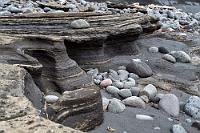 Kurvenreich  Nachdem wir uns einige Zeit mit den Eiderenten und einigen Austernfischern aufgehalten haben, geht es zurück zum Auto. Vorbei an merkwürdigen Auswaschungen im Fels, die zwar den Charakter von Lavagestein haben, andererseits aber so dünn geschichtet sind, wie es typisch für Sedimente ist. Wir sind keine Geologen, es scheint uns aber, als seien über längere Zeit geflossene, dünne Lavaschichten regelmäßig von der Flut abgekühlt und schichtartig übereinander abgelagert worden.  Wie auch immer... kurz vor Erreichen des Parkplatzes geht mir siedendheiß durch den Kopf: "Hast Du das Auto vorhin eigentlich abgeschlossen?". Mit weichen Knien nähere ich mich dem Duster, der immer noch alleine dort parkt und bin sehr erleichtert, als wir feststellen, dass sich offensichtlich niemand an unseren Habseligkeiten vergriffen hat... Puuuh.