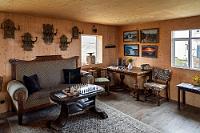 Nichts schuldig geblieben  Das kuschelig eingerichtete Wohnhaus dient dem heutigen Förderverein, dem auch unsere Führerin nebst ihrer Kollegin angehört, als Stützpunkt. Noch während uns Kaffee und Kuchen angeboten werden (die wir dankend ablehnen), trifft eine weitere Kleingruppe von Besuchern ein, derer sich die Kollegin umgehend annimmt.  Laut Reiseführer kostet der unbegleitete Besuch 500 ISK Barzahlung pro Person in die Vertrauenskasse, die am Eingangstor aufgehängt ist. Nun verlangt unsere Führerin aber 1000 ISK p.P., die zwar redlich verdient sind, aber Marens Barschaft sprengt. Da wir keine Betreuung erwarteten, haben wir auch nur etwas über 1000 ISK bei uns. Unser Angebot, den Rest in Euro zu begleichen findet wenig Anklang, es stellt sich aber heraus, dass ein Kreditkartenlesegerät vorhanden ist, mit dem wir uns dann glücklicherweise auslösen können :-).