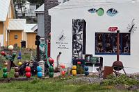 Ortserkundung  Ich sichte ein paar Kragenenten auf dem kleinen See und kehre kurz zum Auto zurück, um das Tele zu holen. Maren macht sich währenddessen mit der anderen Kamera auf den Weg entlang der mit vielen kleinen Läden bestückten Ortsstraße. Sie entdeckt einen "Art and Craft" Shop, ein absolut schräg gestaltetes Haus, bei dem nicht klar ist, ob es sich um eine Künstlerwerkstatt, eine private Installation oder wilden Übermut handelt.  Nach einiger Zeit treffen wir uns am Auto wieder, Maren greift sich das Portemonnaie und beschließt, nochmals zu der 'Kunstgalerie' zurückzukehren, in der Hoffnung, dort vielleicht ein nettes Mitbringsel für Mutti zu finden. Es ist in der Tat ein Kunst- und Souvenierladen, indem auch wirklich schöne Keramikartikel gehandelt werden, die preislich allerdings in ausgesprochen isländische Höhen abheben. Zudem hat Marens Mutter inzwischen eine erkleckliche Auswahl verschiedenster Vasen und Schalen von unseren Reisen gesammelt und Plüschpuffins oder Holzlöffel in Walform sind auch nicht unbedingt das, was Maren gesucht hat.