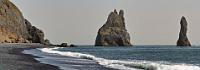 Reynisdrangar  Wobei der Blick als Erstes wohl nicht auf die sich fortsetzenden Basaltformationen fällt, sondern auf die markante Gruppe der freistehenden Reynisdrangar Felsen, die am Ende des Strandes aus dem Meer ragen. Der Sage nach sollen sich zwei Trolle um das Dreimasterschiff Langsamur gestritten haben, als plötzlich die Sonne aufging und die Trolle samt Schiff zu Stein erstarrten. Der erste Troll hieß Landdrangur und ist in der – nach dem Schiff – zweitgrößten Felsnadel verewigt. Aus dieser Perspektive stehen die beiden hintereinander und erscheinen als ein Fels. Der zweite und kleinste Troll hingegen hört auf die Namen Háidrangur oder Skessudrangur und ist der am weitesten draußen stehende Fels.