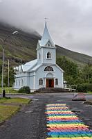 Seyðisfjarðarkirkja  "Bláa Kirkja", die kleine, blaue Kirche ist eines der bekanntesten Wahrzeichen Islands. Sie hat eine wechselvolle Geschichte, stand sie ursprünglich doch auf dem Bauernhof Dvergasteinn, bevor sie 1882 nach Vestdalseyri am nordseitigen Ufer des Seyðis Fjords auf einen Hügel verlegt wurde. 1894 von einem schweren Sturm beschädigt, wurde sie hangabwärts auf einer Halbinsel wieder aufgebaut. Bis man 1920 beschloß, sie an ihren jetzigen Standort im Herzen von Seyðisfjörður zu verlegen...