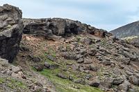 Sönghellir  Wir wollen unser Straßenglück nicht weiter strapazieren und fahren wieder bergab, halten aber noch einmal, um uns ein zugängliches Höhlensystem an einem Lavahang anzuschauen. Dicht unterhalb der Abbruchkante reihen sich fünf, sechs Höhleneingänge hintereinander, von denen nicht ganz klar ist, ob es nur Löcher sind, oder ob einige noch weiter in den Hang hineinführen. Wir haben unsere Taschenlampen im Hotel und sind nicht gerade begierig, in unbekannter Dunkelheit herumzutapern. Es klappt übrigens auch hier wieder: wir waren auf dieser Strecke bisher noch keinem Menschen begegnet, aber gerade eben biegen zwei Autos neben unserem in die Parknische ein :-).