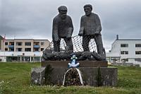 Stadtbummel  Es ist noch keine Hauptsaison und auch das Wetter läßt zu wünschen übrig. Mit 2500 Einwohnern ist Ísafjörður die größte Stadt der Westfjorde, in denen insgesamt noch nicht einmal 5000 Menschen leben. Dementsprechend ist sie auch Ziel aller großen Kreuzfahrtdampfer, deren Passagiere hier eine Menge Trubel verbreiten sollen. Momentan ist allerdings kein Dampfer da, so dass das Städtchen etwas verschlafen wirkt. Den einzigen Stress verbreiten hier Mopedfahrer, die gestern Abend ununterbrochen das Hotel umknatterten. Maren hält es nicht im Hotel, sie schnappt sich die Kamera und macht noch eine kleine Runde, u.a. vorbei an diesem Seemannsdenkmal, welches der zahlreichen Fischer gedenkt, die ihr Leben auf See ließen.  Vor fast 1100 Jahren war es der Siedler Helgi Hrólfsson, der sich als Erster auf der Landzunge niederließ, welche den natürlichen Hafen vom Fjord abgrenzt. Schnell entwickelte sich der Ort zu einem lebendigen Fischereihafen und im Laufe der Jahrhunderte zu einer Handelsmetropole, die auch von Kaufleuten der Hanse angelaufen wurde.