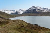 Stífluvatn  Eigentlich hätte es sich angeboten, bereits nach dem Verlassen der Reykjanes Halbinsel am Beginn unserer Reise ein, zwei Abstecher ins Hochland zu machen. Wir nahmen aber davon Abstand, weil Anfang Juni mit ziemlicher Sicherheit die Strecken noch wegen Schnee gesperrt sind. Jetzt sind wir zwei Wochen weiter, die Berge sind im Norden nicht ganz so hoch und dem Meeresklima ausgesetzt, so dass vielleicht die Chance besteht, quer über den Bergrücken der Tröllaskagi Halbinsel nach Akureyri zurückzukehren. Unser Vermieter, den wir heute morgen beim Frühstück befragt haben, ist sich nicht sicher, ob die Straße schon offen ist und hat Zweifel, dass unser Vorhaben gelingt. Wir wagen es einfach mal. Zurück bis an die Südspitze des Miklavatn, biegen wir bei Ketilás nach rechts auf den Ólafsfjarðarvegur ab. Nirgendwo steht etwas von "Sperrung", weswegen wir weiterfahren und erst mit Blick auf die Berge am Stífluvatn pausieren.