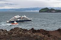 Sturmboote  Wir fahren weiter, treffen wieder auf den Fellavegur, der kurz danach in den Eldfellavegur übergeht und halten auf dem Parkplatz direkt an der Küste. Immer noch weht es so stark, dass aufgewirbelte Gischtfahnen über das Meer zwischen dem Festland und den Inseln tanzen (Island ist zwar auch 'nur' eine Insel, nimmt sich aber gegenüber den vorgelagerten Westmännerinseln eher wie 'Festland' aus ;-). Mit dem auslaufenden, schnuckeligen Kreuzfahrtschiffchen und dem begleitenden Lotsen ist das Motiv jetzt auch perfekt und umgehend im Kasten.