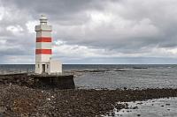 Wegweiser  Spät am Vortag erst um 22:40 Uhr aus Hamburg abgeflogen, erreichen wir nach einem nur dreistündigen, ruhigen Flug den auf einer Halbinsel westlich von Reykjavik liegenden Zielflughafen Keflavik. Da wir auf der Strecke zwei Stunden gewonnen haben, können wir noch vor Mitternacht den Mietwagenvertrag am Hertz-Schalter abschließen, lassen das Fahrzeug aber vorerst noch auf seinem Abholplatz stehen, denn unser Hotel wartet gleich daneben auf unsere erste Übernachtung. Obwohl unser Zimmer gemütlich und ruhig ist, stehen wir am nächsten Morgen bereits um 7:00 Uhr auf, denn wir haben heute viel vor. Nach einem sättigenden Frühstück verfrachten wir unser Gepäck in den nur 50 m vor dem Hotel parkenden Dacia 4x4 und machen uns auf den Weg zum nahegelegenen 'Netto'-Supermarkt, um uns mit Getränken und Marschverpflegung einzudecken. Vor uns liegt eine lange Tagesetappe, da die Sonne aber erst eine Stunde vor Mitternacht für eine kurze Zeit untergeht, steht uns reichlich Tageslicht zur Verfügung. Wir starten zur westlichen Spitze der Reykjanes Halbinsel und nach nur kurzer Fahrt erreichen wir den Garður Leuchtturm, der nicht nur Schiffen den Weg weist – auch wir verstehen ihn als Wegweiser am Beginn unserer auf vier Wochen  angelegten Reiseroute .