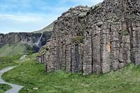 Zwergenheim  Auf der Weiterfahrt halten wir kurz bei der N1 Tankstelle, auf der Maren zwei Prepaidkarten á 20.000 ISK erwirbt. Ursprünglich wollten wir den Sprit eigentlich immer per Kreditkarte zahlen. Der erste Versuch blieb aber unser letzter, denn leider wurde nicht nur die tatsächlich getankte Summe, sondern ein offensichtlich fiktiver Maximalbetrag von umgerechnet etwa 250€ auf der Karte geblockt. Da vollkommen unklar blieb, nach welcher Zeit die Bank diese Summe wieder freigeben würde und wir nach mehrmaligem Tanken womöglich das Kartenlimit erreicht hätten, entschieden wir uns, ab jetzt nur noch per Prepaid-Karte den Durst unseres Dusters zu stillen.  Linksseitig der Straße tauchen nacheinander mehrere kleine Wasserfälle an den Bergflanken auf. Der vom Winde verwehte Systrafoss ist uns ein paar Fotos wert, ebenso wie der Foss à Sidu, dessen Wasser nicht einmal den Boden erreicht. Hier ist er von der schräg gegenüber liegenden Felsformation Dverghamrar aus zu sehen, auf deren Parkplatz wir als nächstes halten.