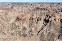 Felszeichnungen  Mit 650 km Länge ist der Fischfluß der längste Fluß Namibias. Berücksichtigt man, dass hiesige Flüsse überhaupt nur in der Regenzeit nennenswerte Mengen an Wasser transportieren, braucht es schon eine Menge Fantasie, sich den Zeitrahmen und die Kräfte vorzustellen, die es benötigte, solche Spuren im basaltischen Fels zu hinterlassen.  Wer den Canyon hautnah auf sich wirken lassen möchte, kann dies während einer vier- bis fünftägigen Wanderung auf dem 86 km langen Trail tun. Obwohl eine aktuelle ärztliche Fitnessbescheinigung Voraussetzung zur Teilnahme an dieser Tour ist, melden sich jährlich bis zu 1000 Hiker für diese körperliche Herausforderung an. Tagesetappen von 20 km mit Temperaturen bis zu 40°C bei einem Verzicht auf jeglichen zivilisatorischen Komfort, erfordern neben entsprechender Erfahrung auch ein gerüttelt Maß an masochistischer Veranlagung. Aber wer's mag...